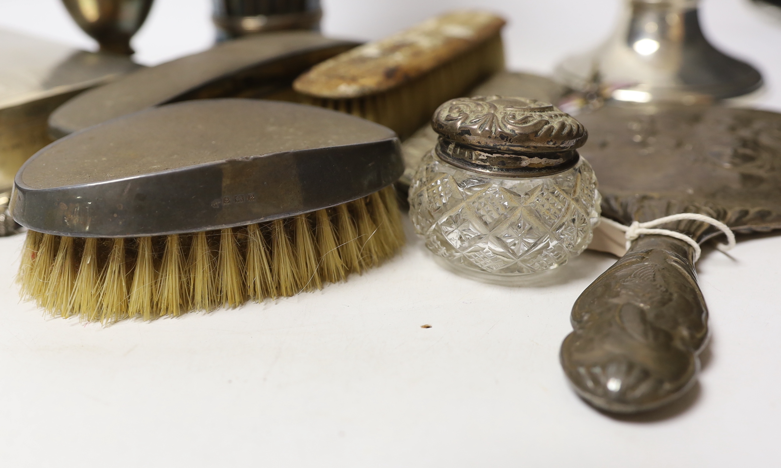 A group of sundry silver including an Edwardian demi-wrythened vase, London, 1901, 24.3cm, mounted hand mirror and three brushes, cigarette box, sugar caster and a damaged inkwell, together with a 1970's silver and ename